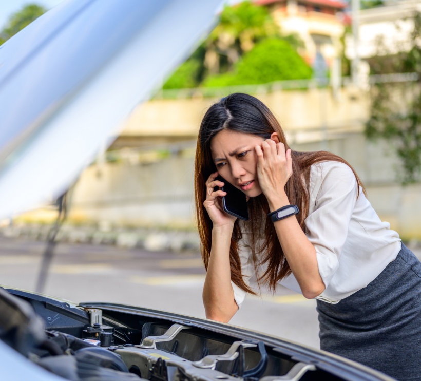 Kobieta patrząca w silnik samochodu