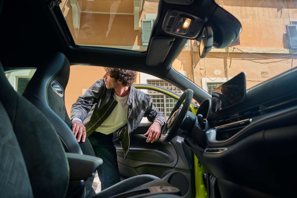 Młody męzczyzna zagląający do wnętrza auta marek Stellantis