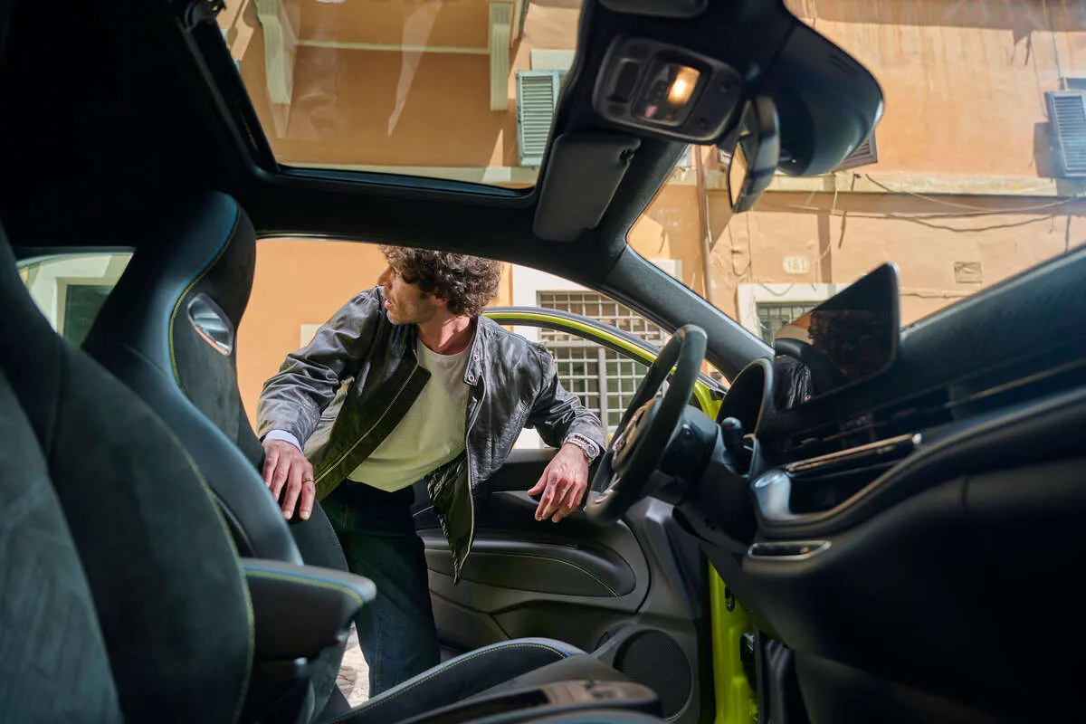 Młody męzczyzna zagląający do wnętrza auta marek Stellantis