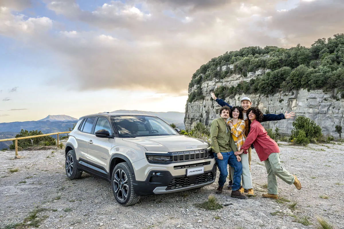 Szczęśliwa czwórka znajomych opiera się o auto