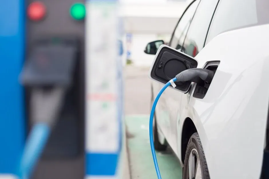 Proces ładowania białego auta elektrycznego